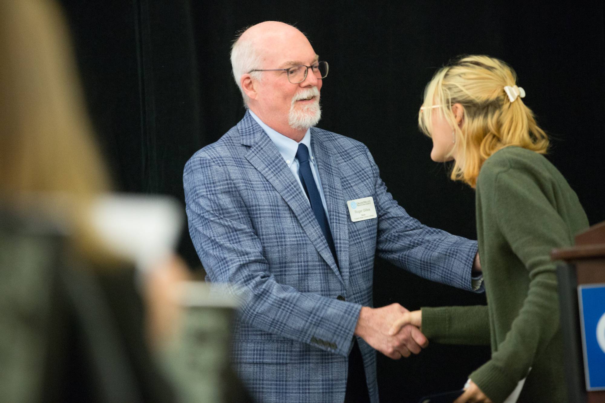 Honors graduate shakes hands with Dr. Roger Gilles.